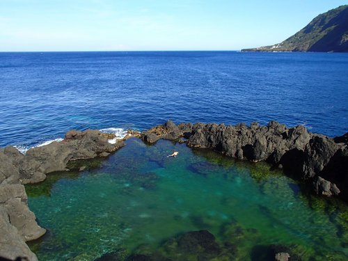 Vor dem weiten Atlantik liegt ein eingefriedeter Naturpool auf der Azoreninsel São Jorge.