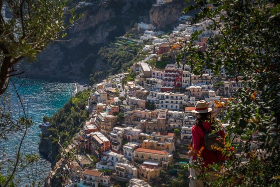 Ein Wanderer schaut von oben auf das sich die Steilküste hinaufziehende Positano.