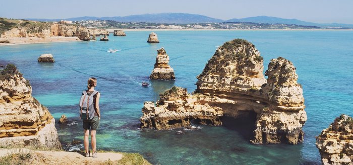 Eine Wanderin blickt auf das Meer an der Algarve