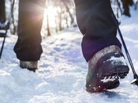 Wanderschuhe im Schnee Schuhe eines Wanderers im Schnee