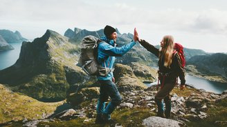 Ein Pärchen gibt sich ein "High Five" nach einer Bergwanderung.