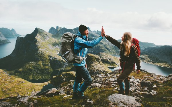 Ein Pärchen gibt sich ein "High Five" nach einer Bergwanderung.