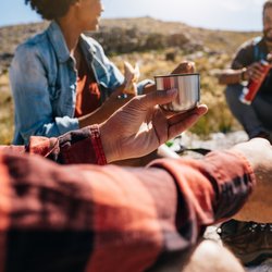 Eine Wandergruppe macht eine kurze Wanderpause und stärkt sich.