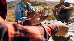 Picknick-Pause beim Wandern mit Freunden Eine Wandergruppe macht eine kurze Wanderpause und stärkt sich.