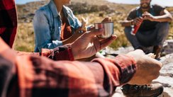 Eine Wandergruppe macht eine kurze Wanderpause und stärkt sich.