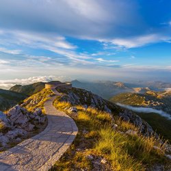Gepflasterter Wanderweg mit Aussichtspunkt auf den Bergen des Lovcen Nationalparks in Montenegro.