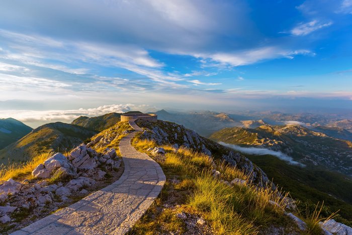 Gepflasterter Wanderweg mit Aussichtspunkt auf den Bergen des Lovcen Nationalparks in Montenegro.