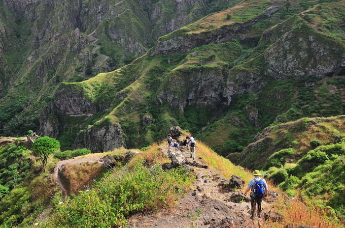 Eine Wandergruppe läuft auf einem Wanderweg in der bergigen Landschaft Kapverdens.