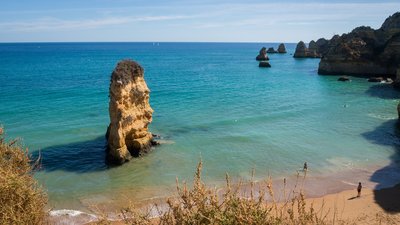 Blick auf den Strand und Felsen im Meer in der Algarve in Südportugal.