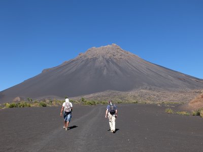 Zwei Wanderer laufen dem Vulkan Pico do Fogo auf der Kapverden-Insel Fogo entgegen.