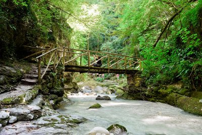 Eine Brücke führt Wanderer über einen Fluss in den Abruzzen, Italien.