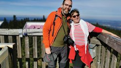 Die Wanderung ist geschafft! Ein Pärchen lächelt glücklich in die Kamera