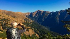 Mann fotografiert mit seinem Handy das Gebirge 