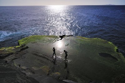 Zwei Frauen planschen zwischen Moss und Wasser auf São Nicolau