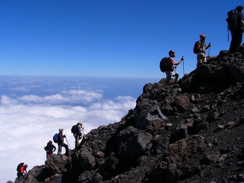 Hoch hinaus: Aufstieg zum Pico do Fogo Eine Gruppe Wanderer erklimmt ausgerüstet mit Wanderstöcken eine steile Bergflanke.