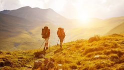 Zwei Wanderer in den Bergen bei Sonnenuntergang