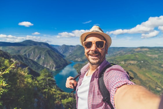 Entspannt unterwegs mit leichtem Gepäck Ein Wanderer fotografiert sich vor traumhafter Landschaft