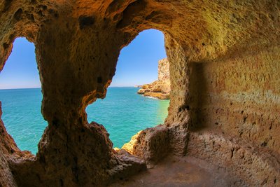 Blick auf das Meer durch ein Loch in einem Felsturm an der Algarve