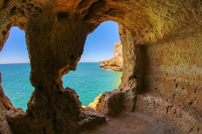 Ausblick aus den Höhlen von Algar Seco an der Algarve Blick auf das Meer durch ein Loch in einem Felsturm an der Algarve