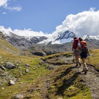 Zwei Wanderer laufen auf einem Bergwanderweg in Italien.