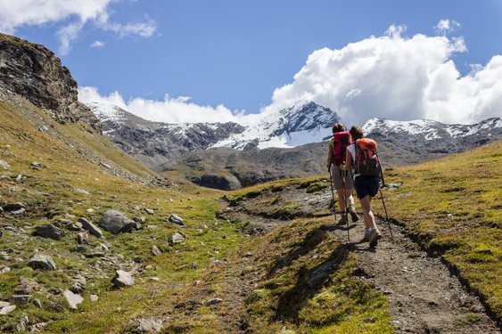 Zwei Wanderer laufen auf einem Bergwanderweg in Italien.