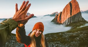 Wandern in Norwegen Zwei Wanderer geben sich ein "High Five" nach einer Bergbesteigung.