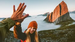 Wandern in Norwegen Zwei Wanderer geben sich ein "High Five" nach einer Bergbesteigung.