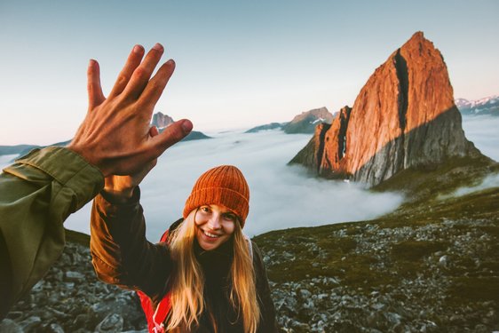 Wandern in Norwegen Zwei Wanderer geben sich ein "High Five" nach einer Bergbesteigung.